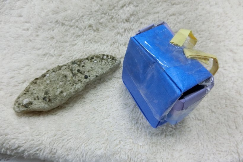 おりがみで作ったランドセルと石の写真