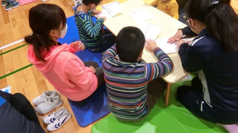 先生と協力してヒコーキを折る様子