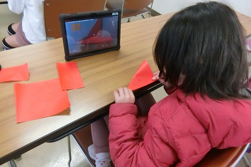 タブレットを見ながら折り紙