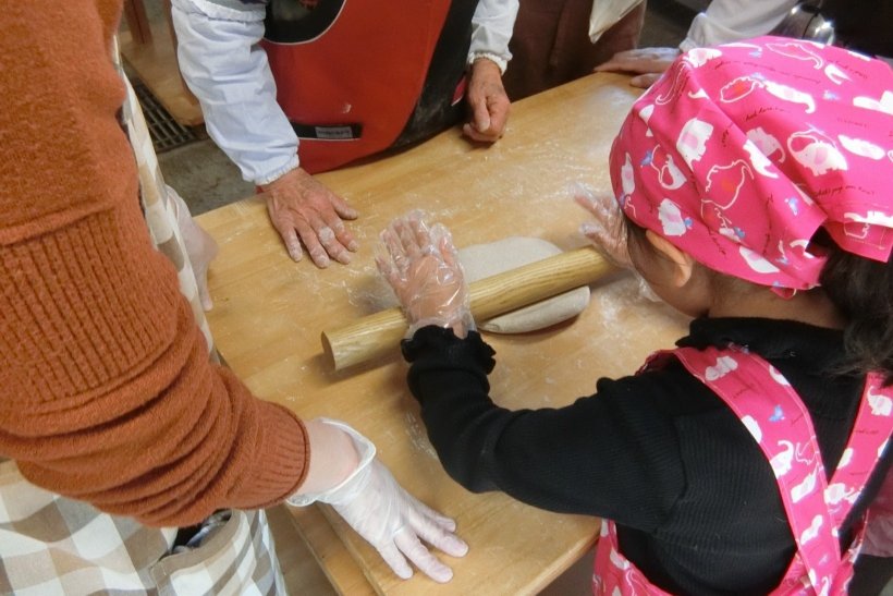 そばをめん棒で伸ばしている