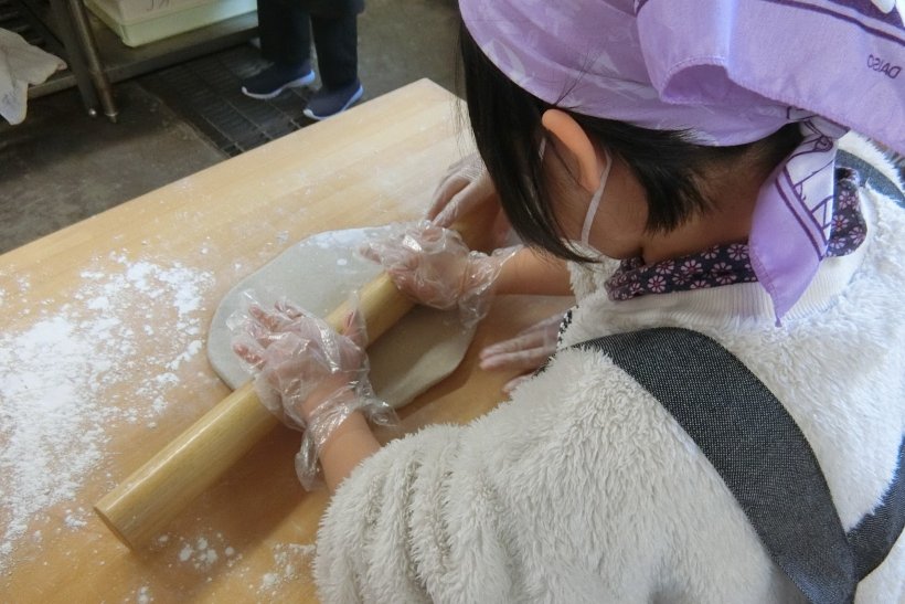 そばをめん棒で伸ばしている