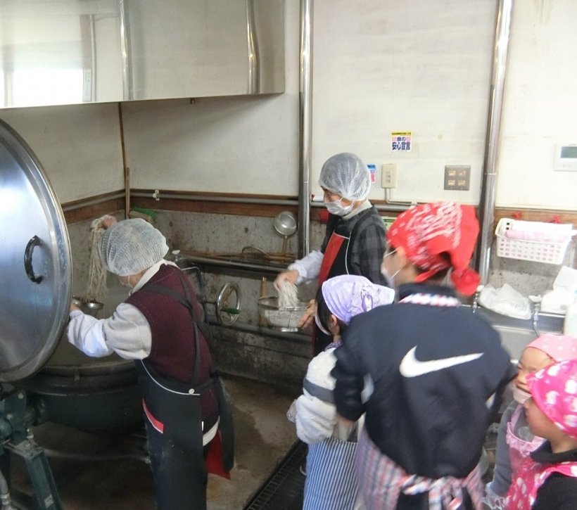 大きな鍋にそばを入れている