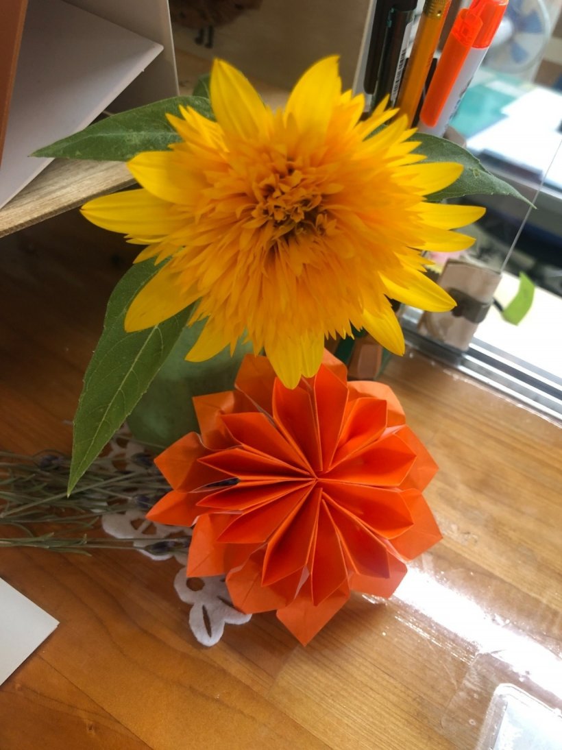花瓶に生けられた黄色の花と折紙で作ったダリア