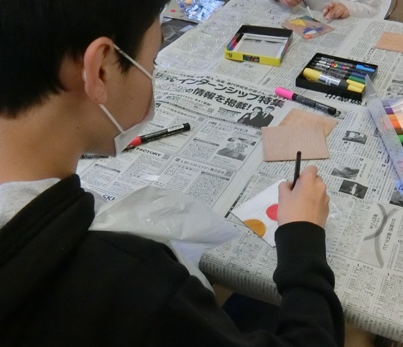 木に筆で絵を描いている