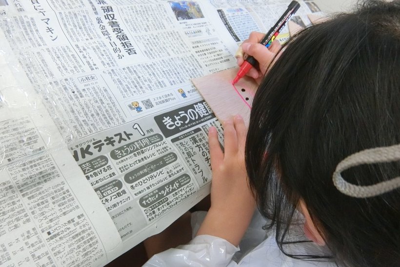 板にポスカで絵を描いている