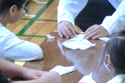 紙ヒコーキを折っている