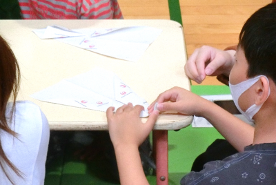 紙ヒコーキを折っている