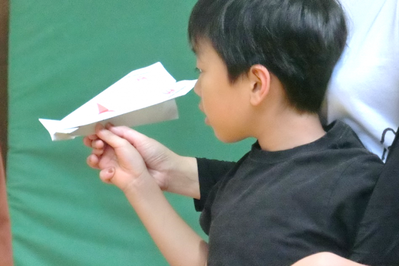 できあがった紙ヒコーキを飛ばす様子