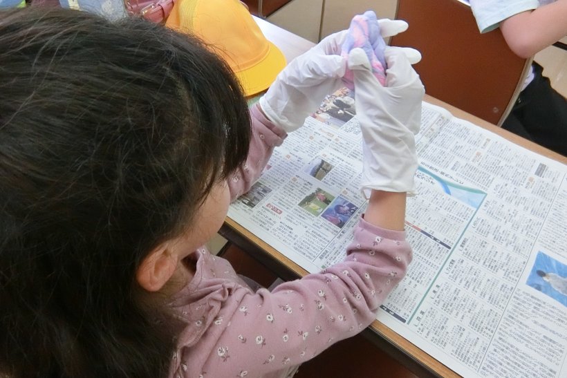 手袋をして粘土をこねている