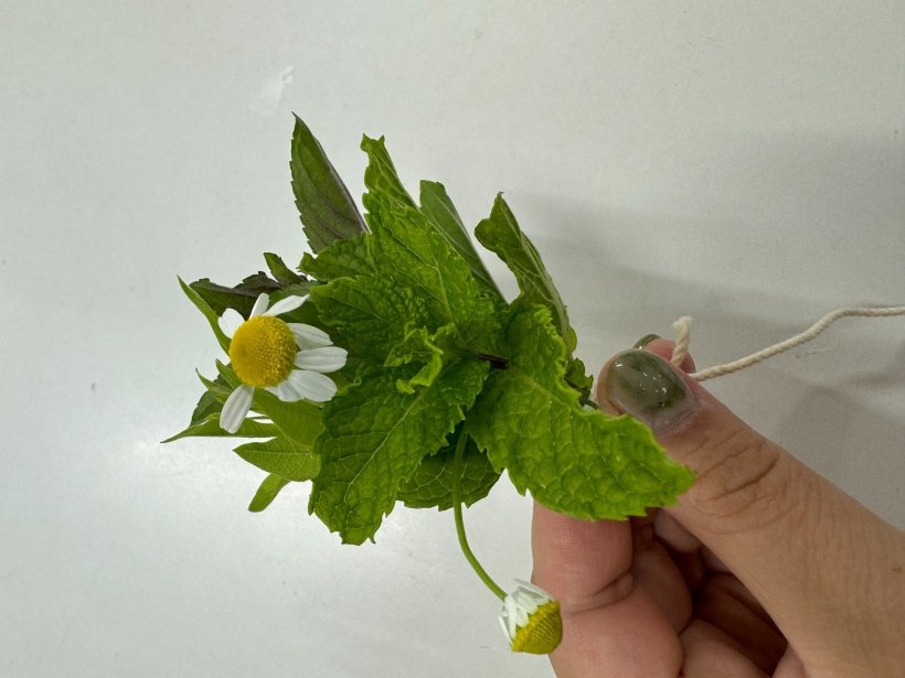 ハーブのブーケを持っている