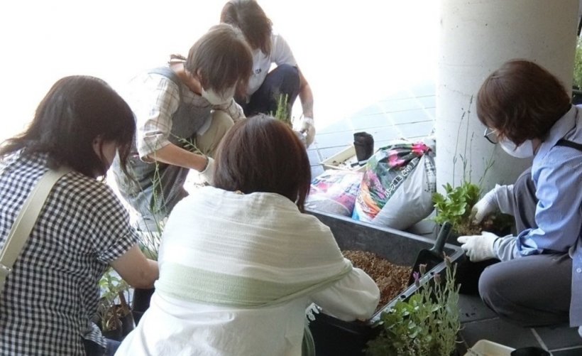 5人が鉢に土を入れている