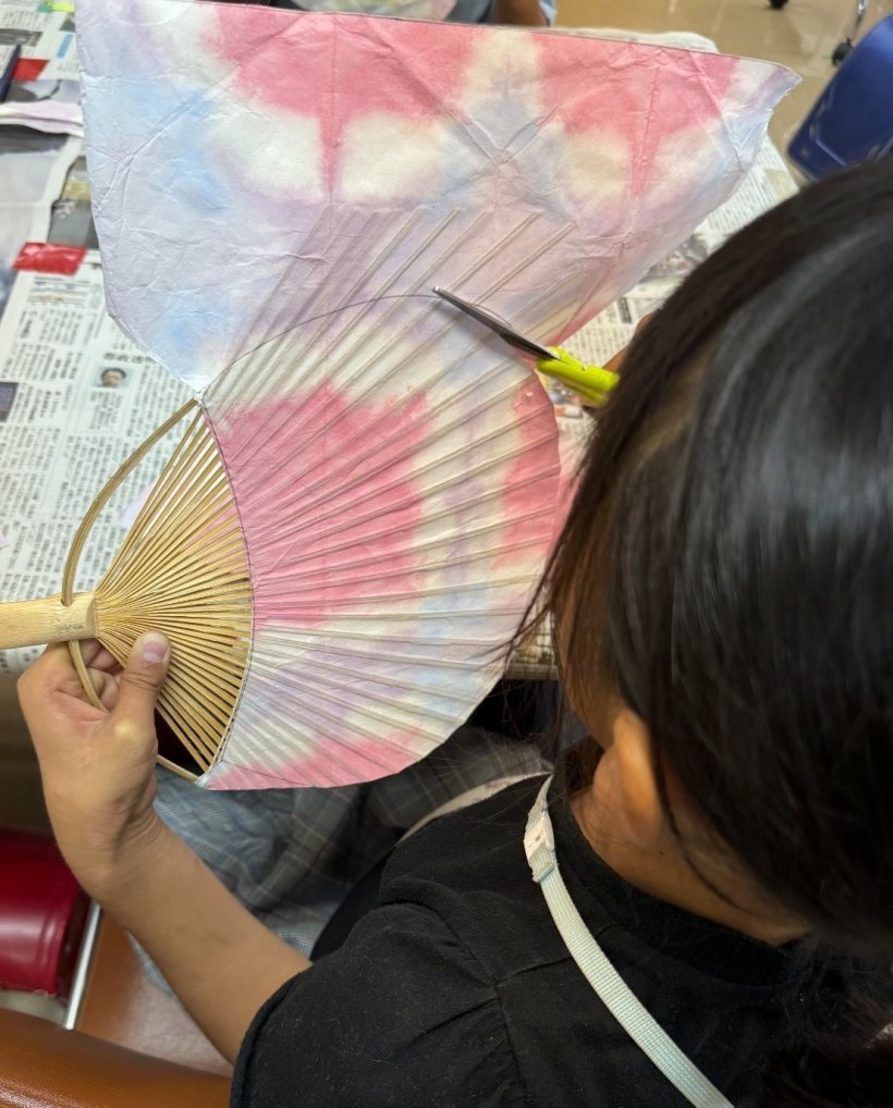 ハサミで型に沿って切っている