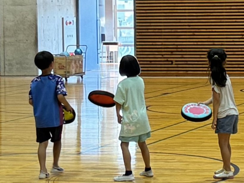 3人でフリスビーを投げようとしている