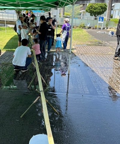 一直線に組まれた流しそうめんの台に集まっている