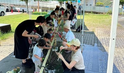 親子で流しそうめんをとっている