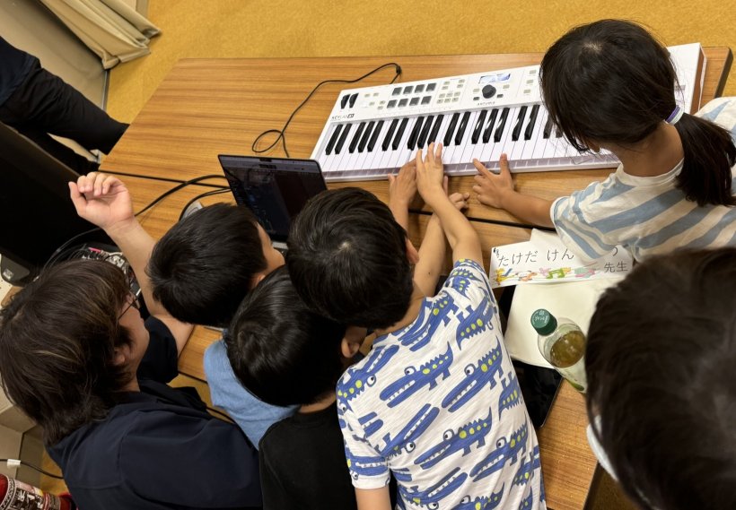 キーボードを触っている子ども、パソコンを触っている大人