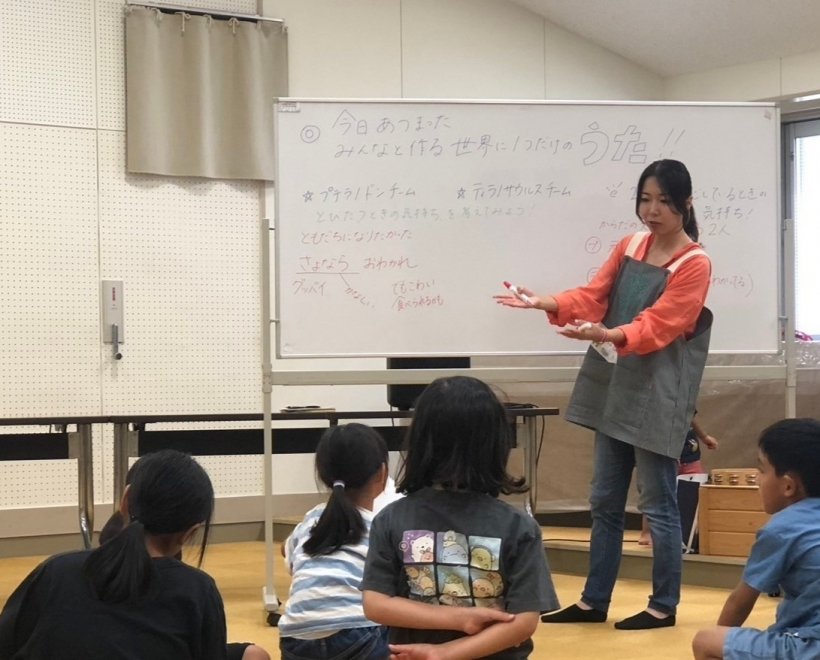 ホワイトボードに向かい話をしている