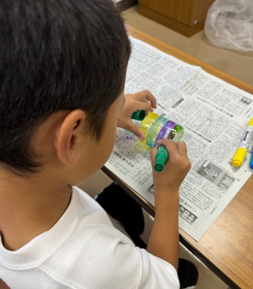 ペットボトルに色を塗っている