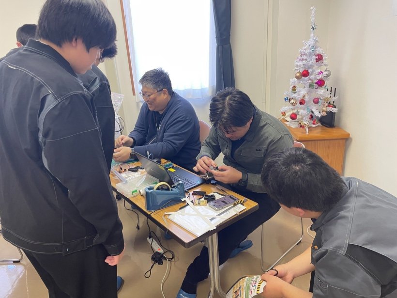 先生と高校生が修正をしている