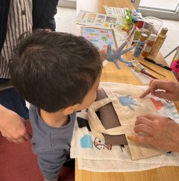 トートバッグに手形を押して手を開いている