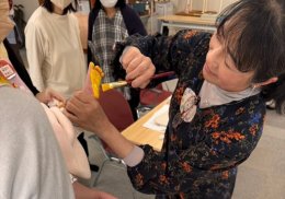 子どもの足の裏に絵の具を塗っている