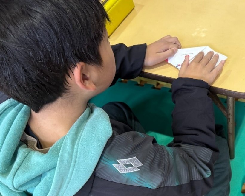 紙ヒコーキを折っている