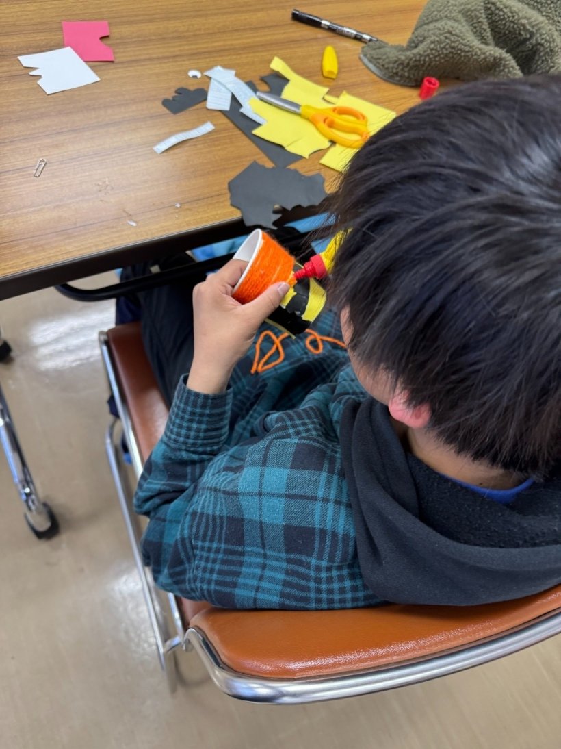 紙コップにボンドで毛糸をつけている