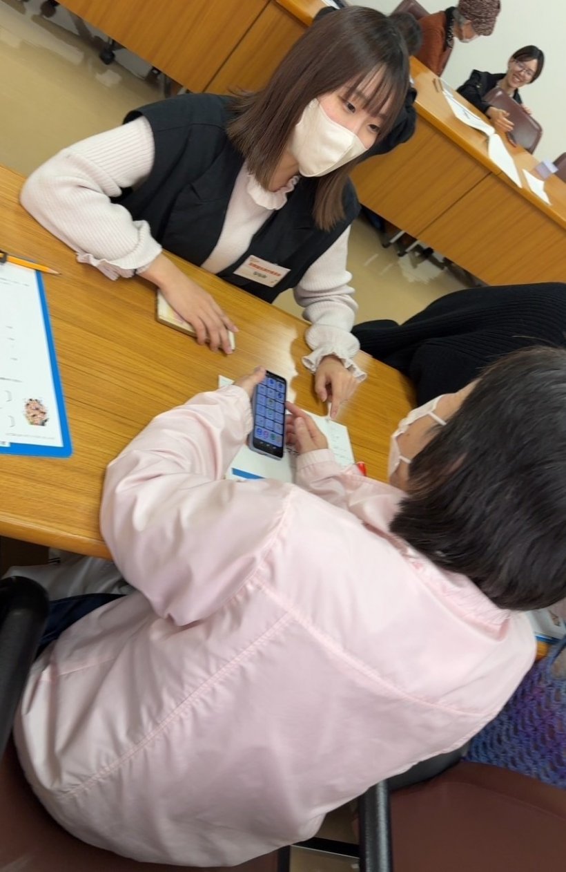 大学生が参加者に教えている様子