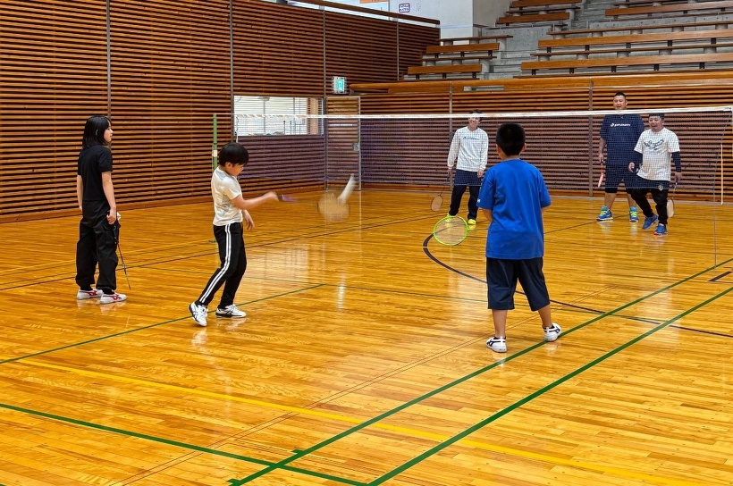 大人と子どもでバドミントンをしている