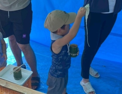 そうめんをすくい上げる子ども