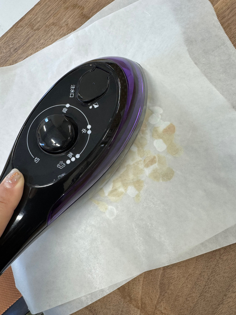 刻んだふたを挟んだクッキングシートにアイロンをかけている