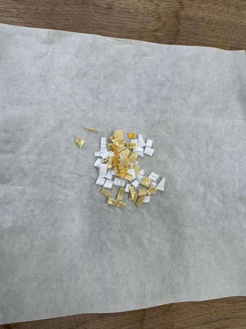 ペットボトルのふたを切ったものをクッキングシートにのせている