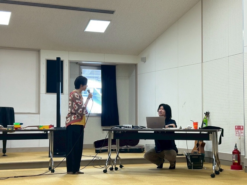 向かい合って歌を歌う人と音を合わせている人がいる