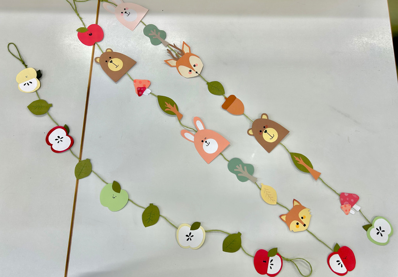 画用紙で作った動物、リンゴなどを糸で繋げたガーランド