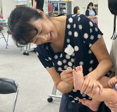 子どもの足に絵の具を塗る川田真由美先生