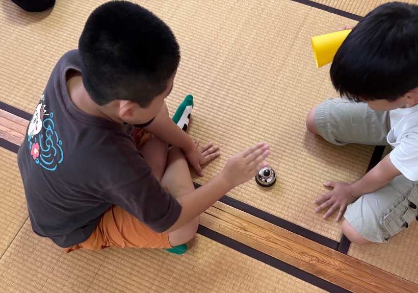 ベルとコップを使って2人で遊んでいる