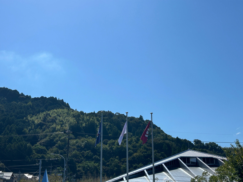 青空と山、旗が風になびいている様子