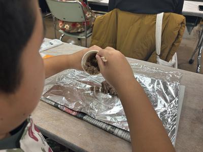 紙コップに入ったロウを割り箸でかき混ぜている様子