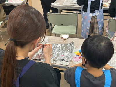 親子で隣に並んで一緒にロウをこねている様子