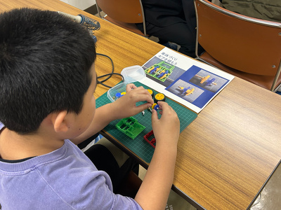 参加者の小学生が車体の内部パーツを組んでいる様子