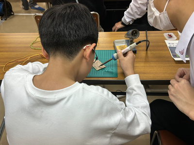 参加者の小学生がはんだづけをしている様子