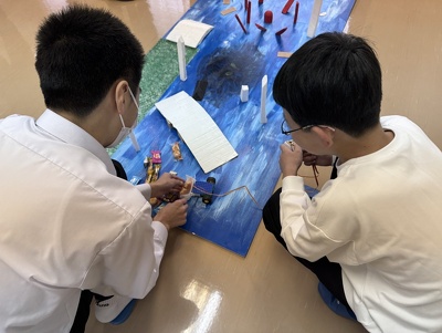 参加者の小学生が作った車型ロボットを操作してコースを走らせている様子