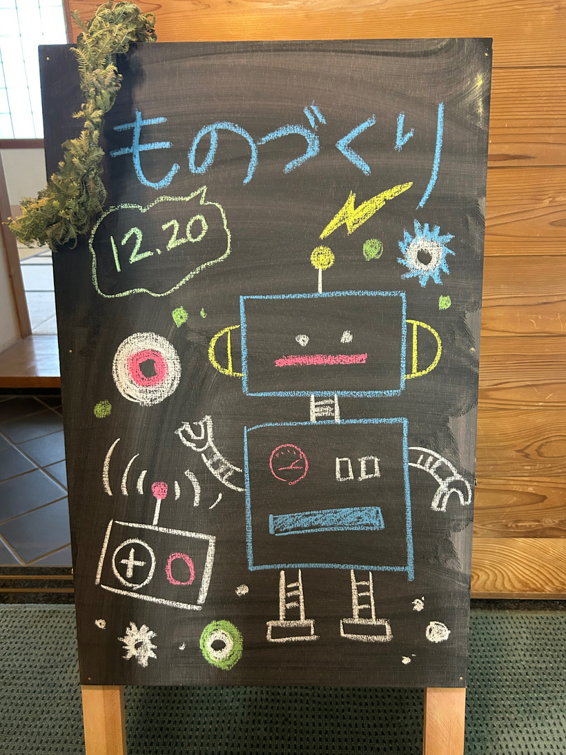「ものづくり」という文字とロボットのイラストが描かれた黒板の立て板