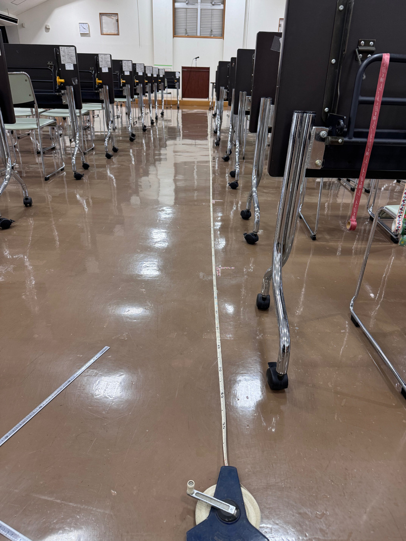 机の横にメジャーを引っ張っている