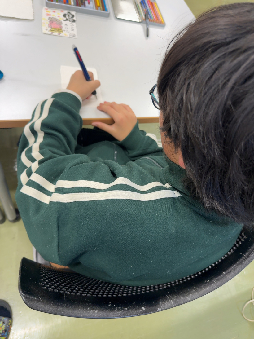 ハガキに書き物をしている