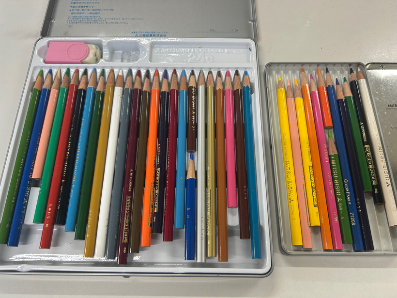 色鉛筆セット2つを机に並べている