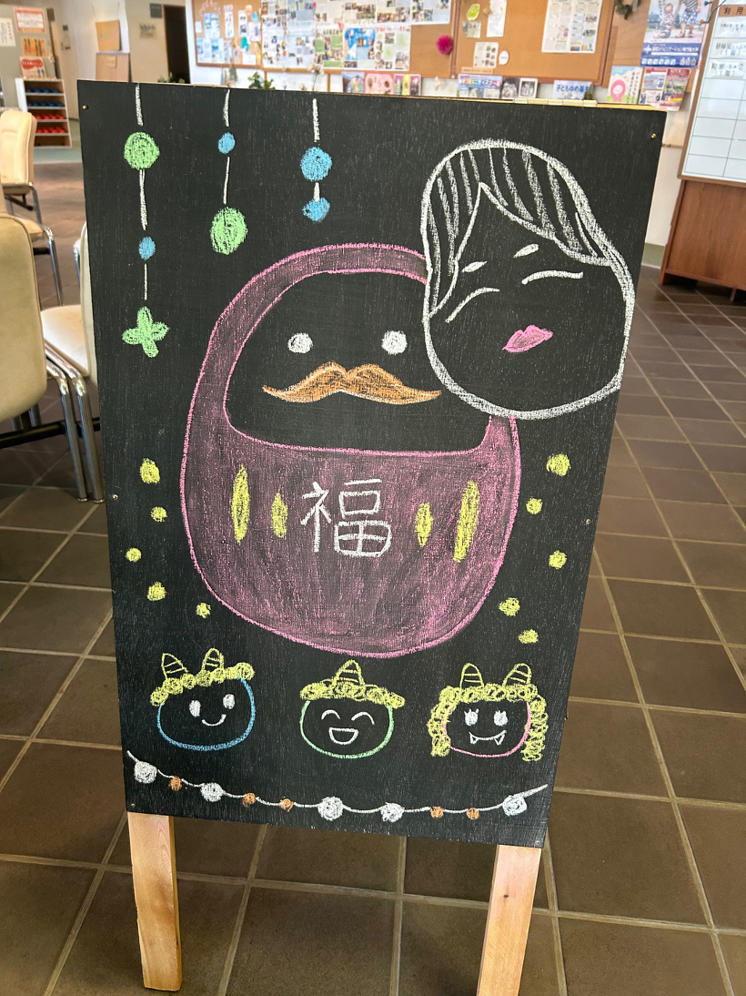 黒板の立て看板に描いたダルマと小鬼のイラスト