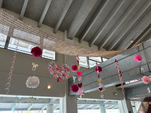 ロビーの吹き抜けを数種類のハートの吊るし飾りで装飾している