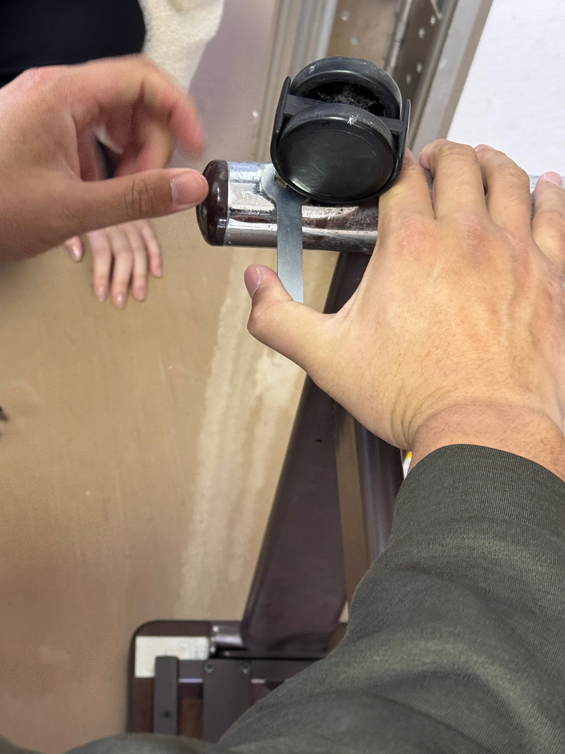 机のキャスターを外している