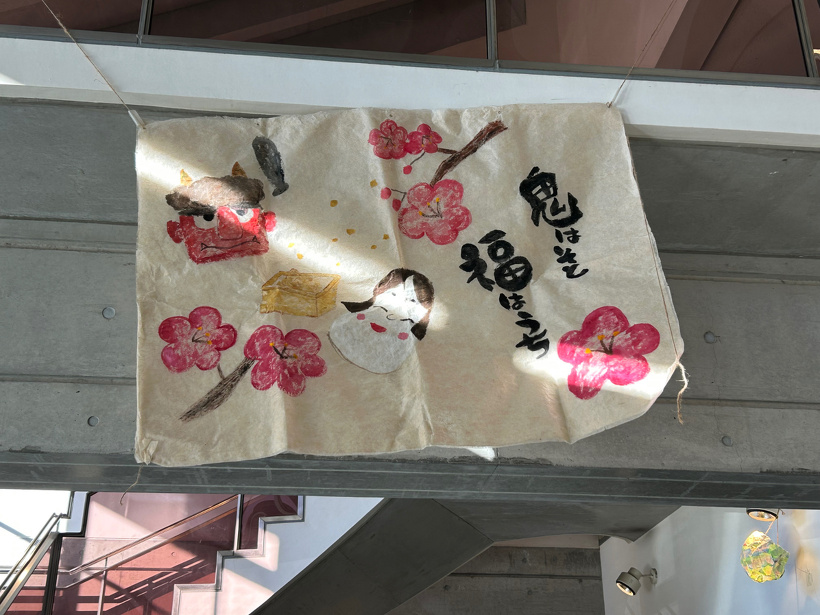 福の神や鬼を描いた和紙を２階の手すりから吊るしている